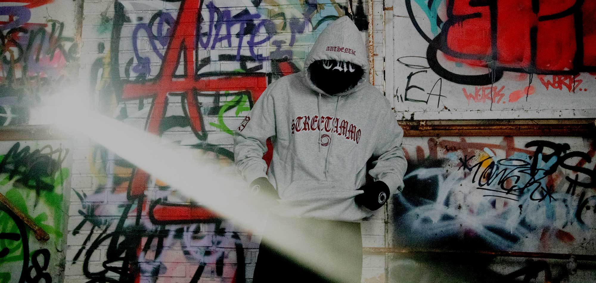 Rear view of a hip hop graffiti sprayer with baggy pants and hoody
